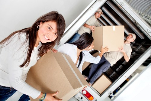 Movers carrying boxes near Hampton residential properties